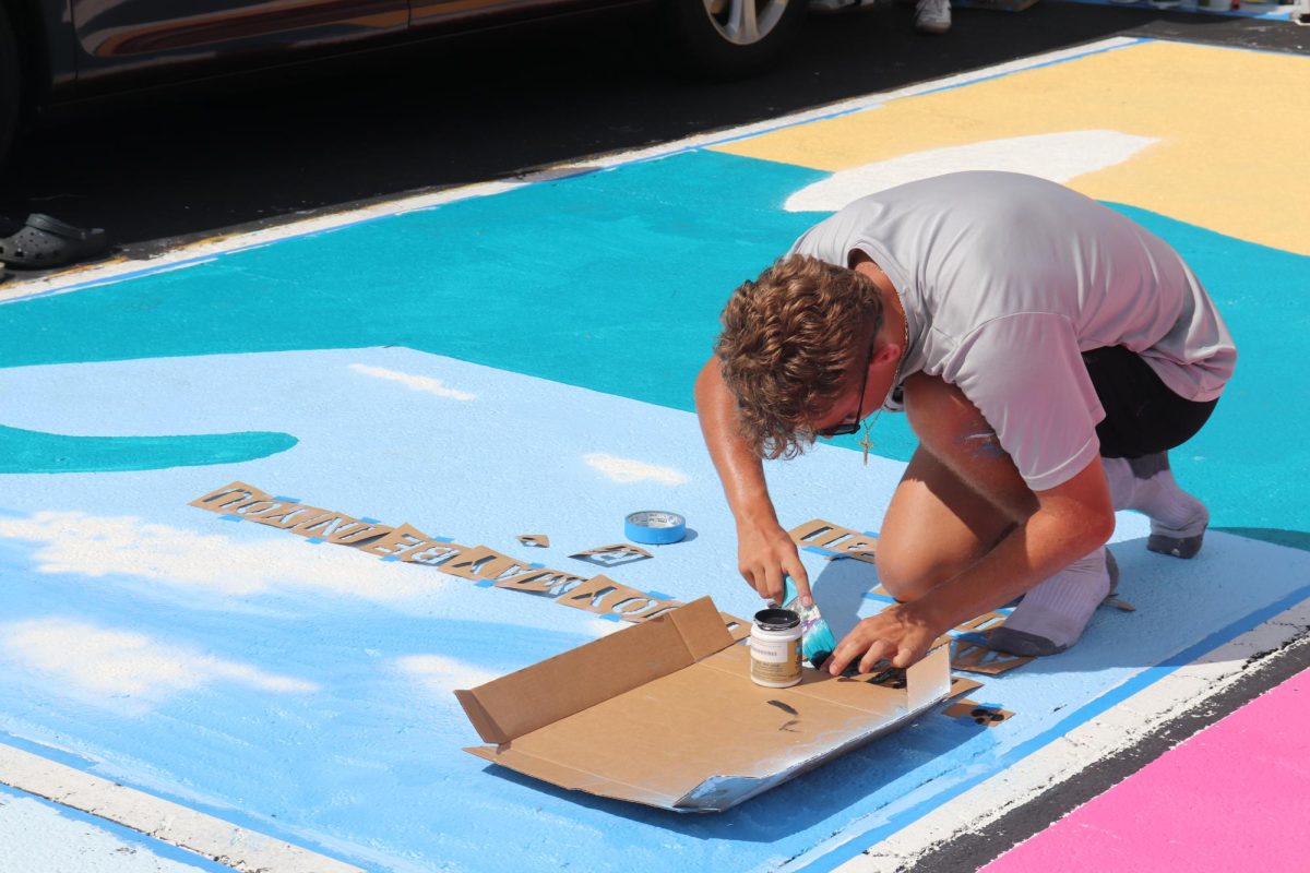 Senior Christian Thein paints his parking spot on Sept. 7.