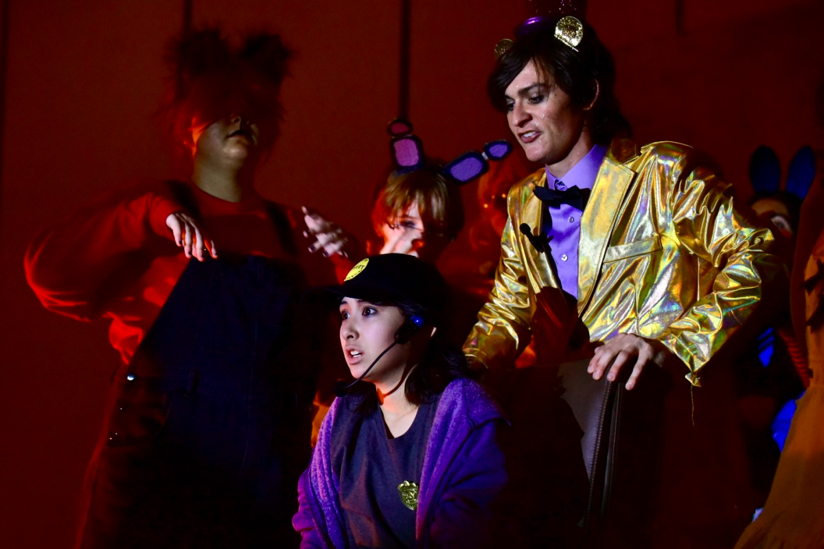 Class of 2024 alumnus Spencer Wilson (right) acts onstage alongside sophomore Cathryn Cooper (bottom center), eighth grader Finnegan Darby Bennett (top center) and junior Michael Dempsey (left) on July 20. “I played the character Golden Freddy, which was the exposition dump character of the first half of the show,” Wilson said. “But in the actual production in its entirety, I helped with getting the actors in order, I directed a little bit, and helped some of the new actors get into character. I also assisted with the choreography. I just did a bit of everything, helping out where I can.”
