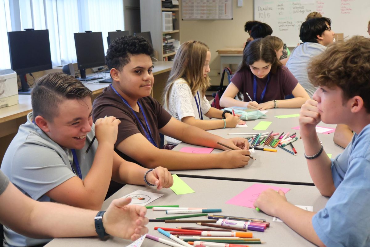 Sophomore Logan Nemroff (right) jokes with seventh grader Jaxson Vasso (left) and sophomore Eddiel Torres (center) for a mentoring meeting on Aug. 29.