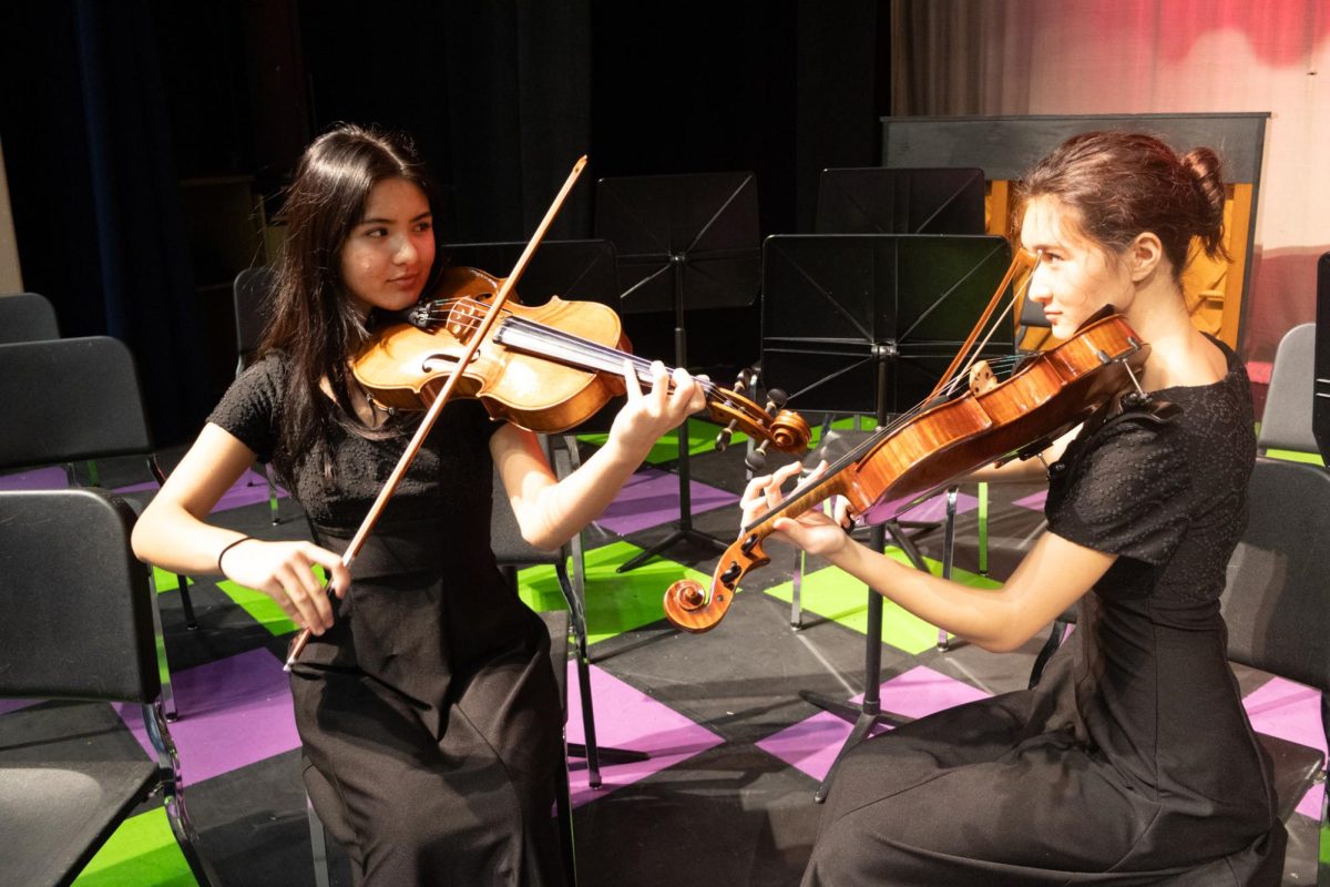 Playing show pieces, junior Presley Haney (left) and senior Peyton Haney (right) practice eye contact before the Dec. 5 winter concert.