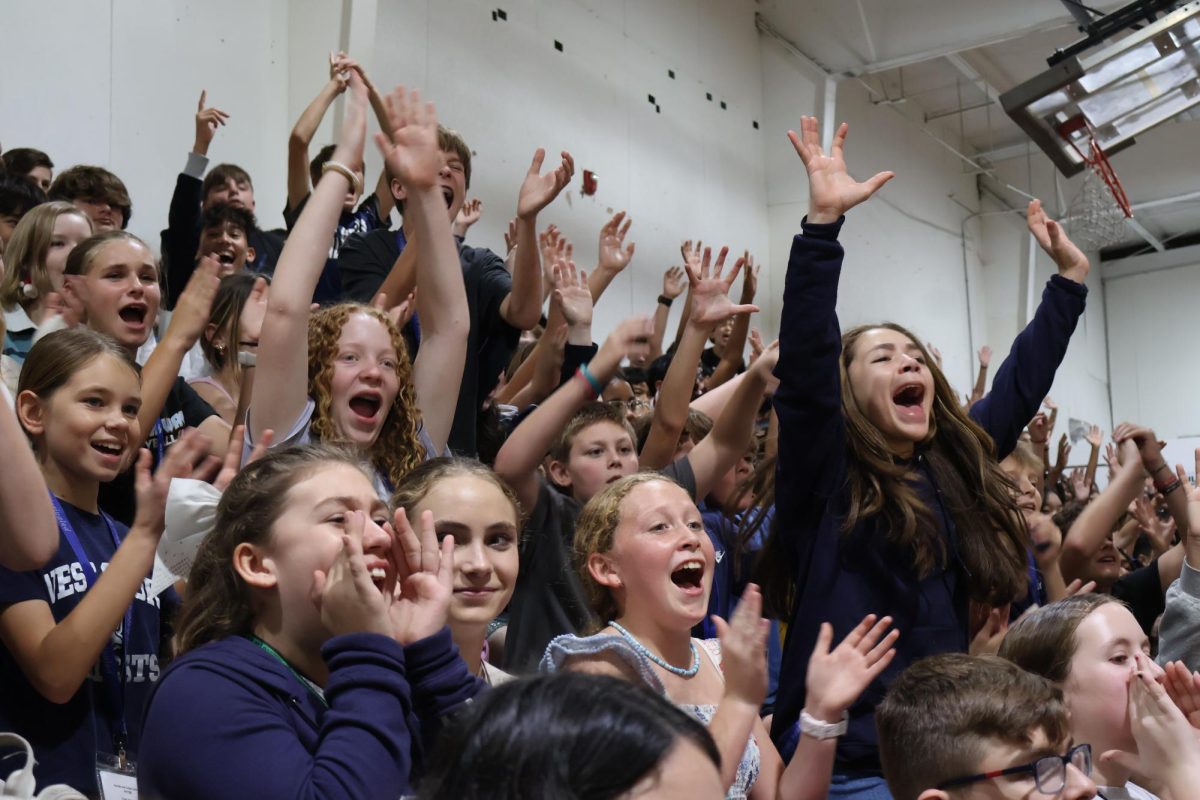Watching BMX bikers do flips in the gym, seventh grader Sarah Amador (right, dark blue) cheer at the The No Hate Tour BMX Stunt Show on Nov. 21. “I really enjoyed how they mixed their stories with BMX and how they kept wanting us to be even louder, so they were like ‘Keep screaming, keep screaming!’” Amador said. “I think that was the funnest part.”
