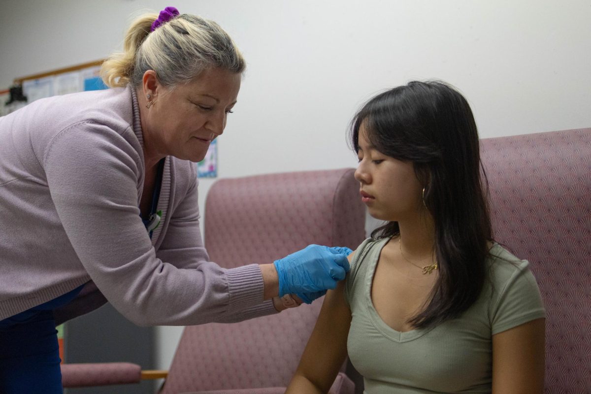 In the nurse’s office, school nurse Kasie Shannon (left) places a bandage on sophomore Tiffany Duong’s arm on Dec. 5.