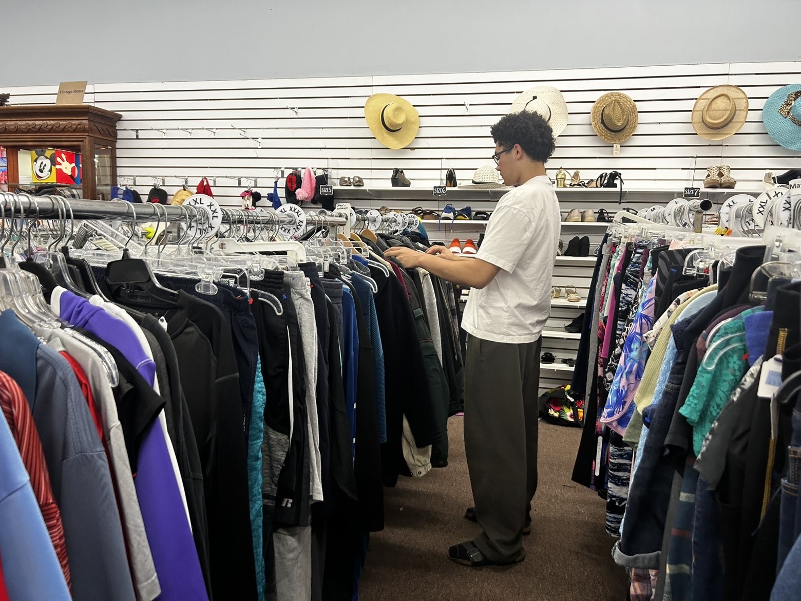 Thrifting at Melbourne's' local store Village Thrift, junior Logan Walsh searches through the men’s jacket section on Dec. 6.