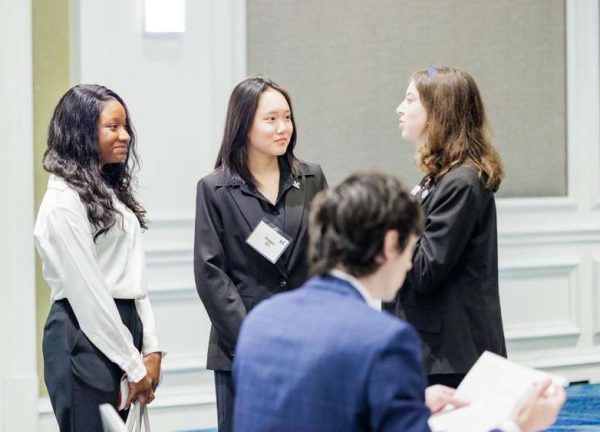 At the National Incubate Debate Competition, junior and Congressional debater Maggie Qin discusses the bills with fellow Congresswomen on May 31, 2025.