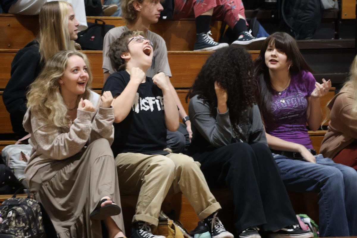 Reacting to the senior class candidate speeches in the gym on Wednesday, April 22, juniors Shae Miller (left) and Ezra Yoro cheer on their class. 