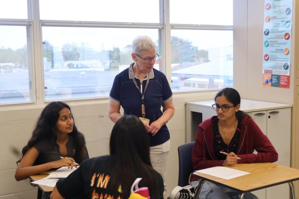 Standing next to her students, AP Language and AP Seminar teacher Jeanne Griffin gives advice to her AP Capstone class.